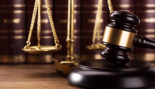 Legal aid in family law with a gavel and scales of justice against a background of law books.