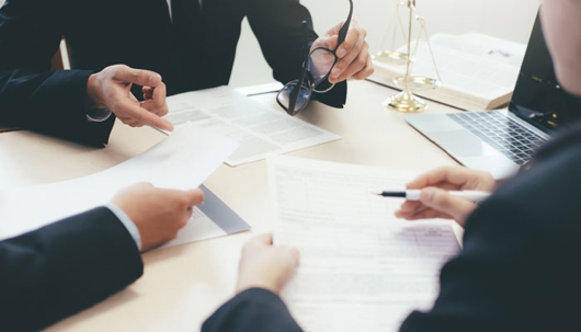 Business people reviewing legal documents at a table