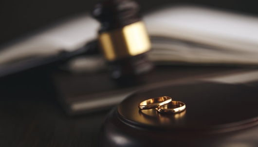 closeup shot of a gavel and 2 wedding rings