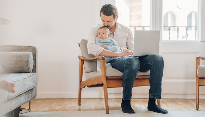 a father sits and holds his young child