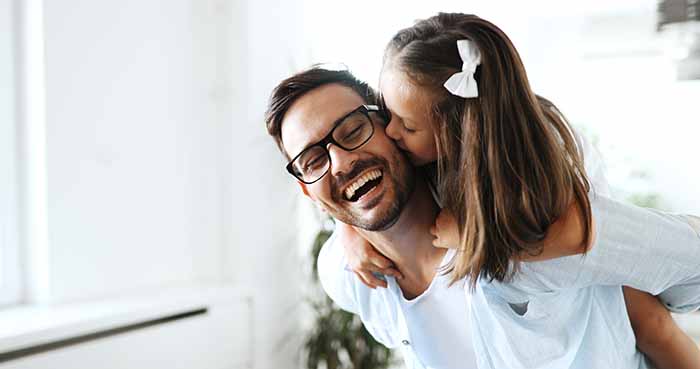 Portrait of father and daughter playing at home together