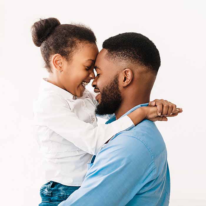 Father hugging with daughter, touching foreheads over white background